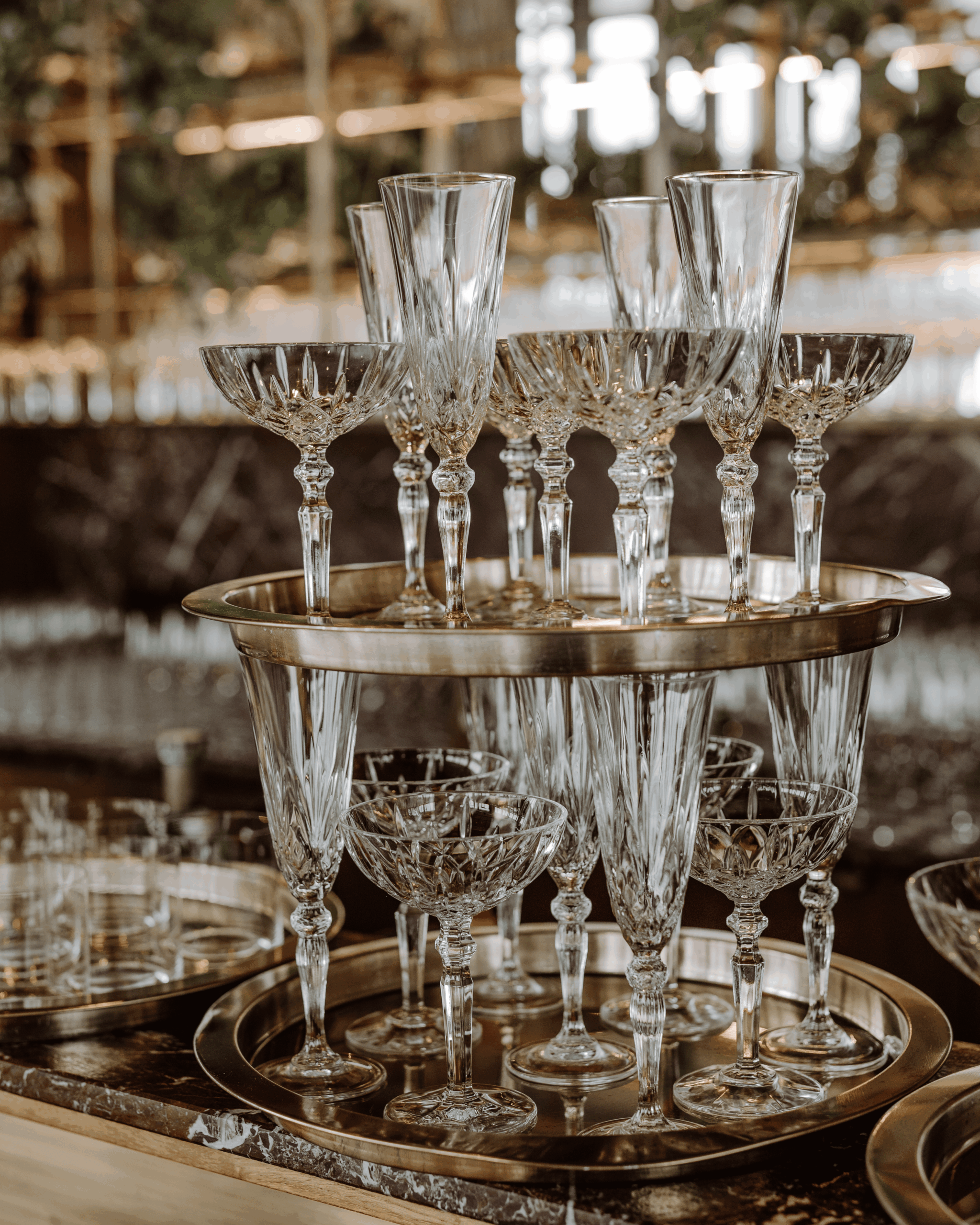 Detailaufnahme von eleganten Kristallgläsern auf goldenen Tabletts