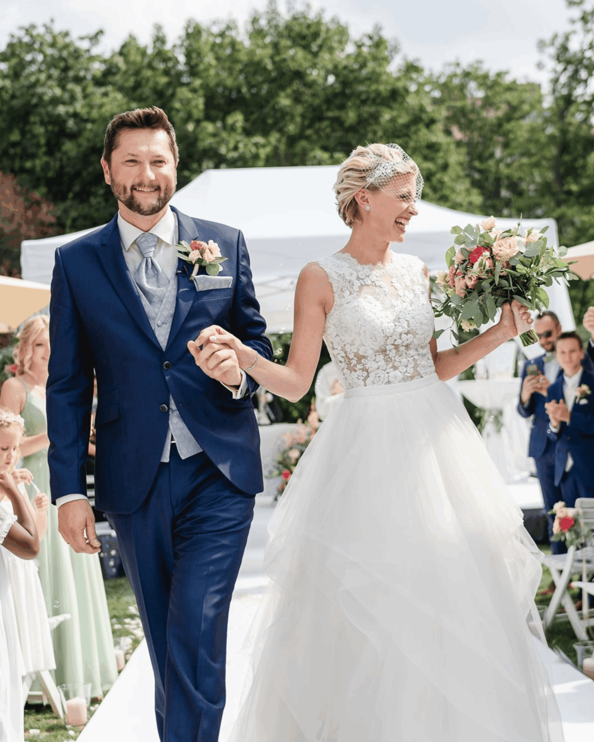 Brautpaar verlässt die Trauung Hand in Hand unter Applaus der Gäste