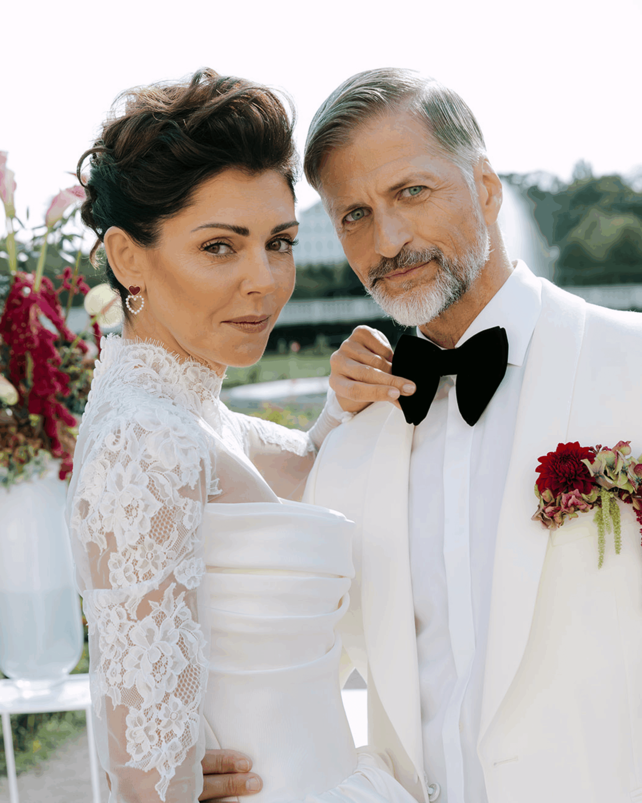 Stilvolles Brautpaar in weißem Hochzeitsoutfit bei exklusiver Outdoor-Hochzeit