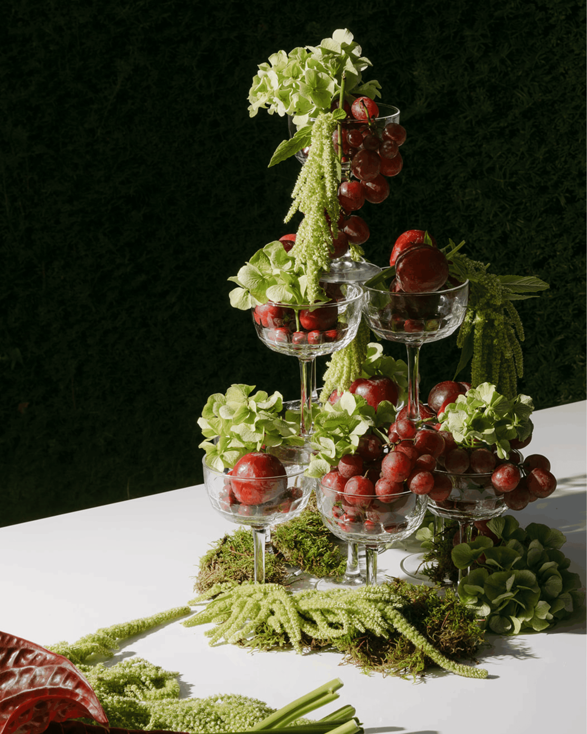 Künstlerische Hochzeitsdekoration mit Trauben, Gläsern und floralen Elementen